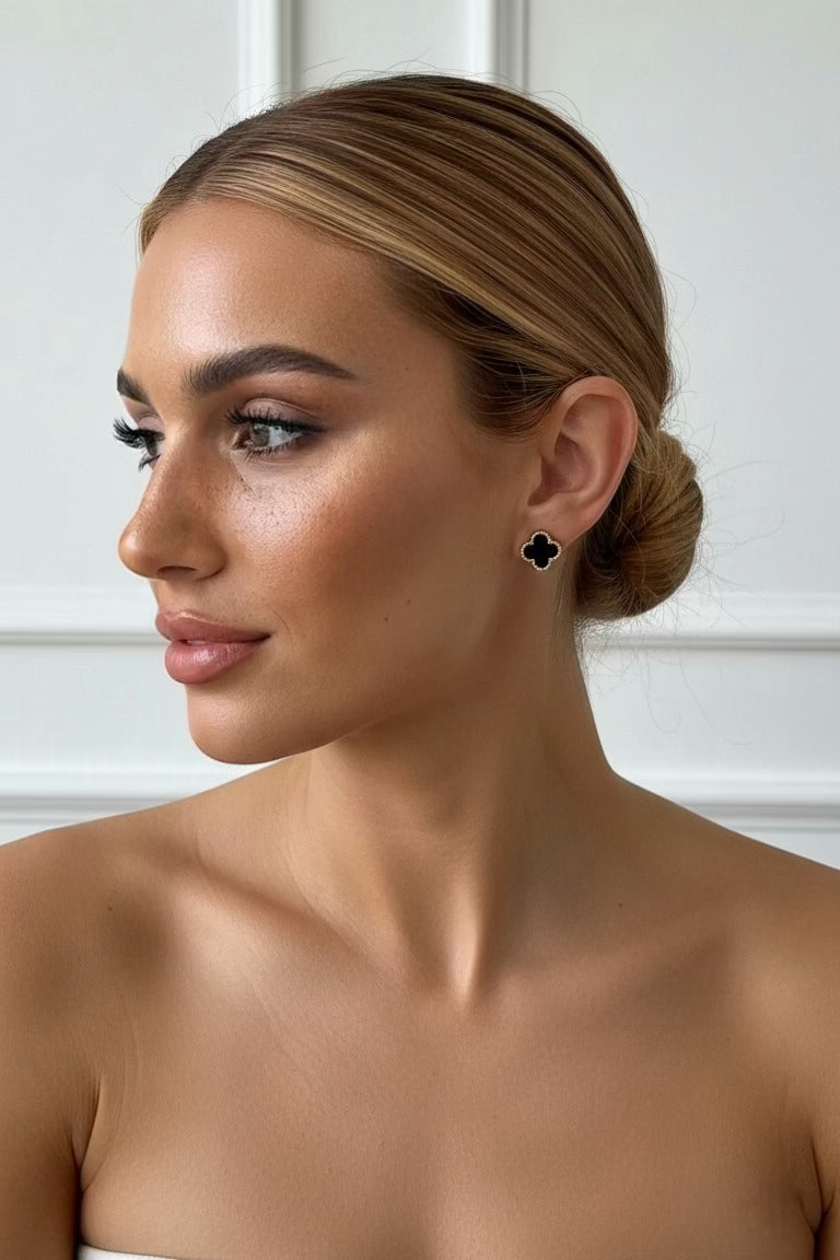 Woman wearing black earrings against a white background